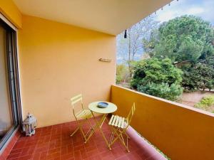 eine Terrasse mit einem Tisch und Stühlen auf dem Balkon in der Unterkunft ''Les Grangettes'' Studio climatisé, proche plage in Sète