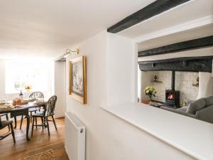 a living room with a table and a fireplace at Lime Cottage in Bridport
