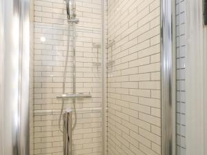 a shower with white subway tiles in a bathroom at Lime Cottage in Bridport +27 photos