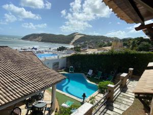 uma vista para uma piscina e para o oceano em Apartamentos Ponta do Sol em Natal