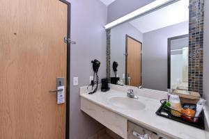 a bathroom with a sink, mirror, and toilet at Americas Best Value Inn - Seymour in Seymour