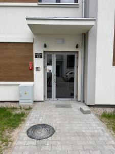 a door to a building with a manhole in front of it at Golden Apartment Lodz, Zdrowie in Łódź