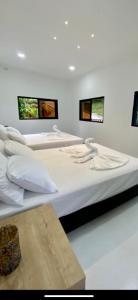 3 camas en una habitación con 3 monitores en la pared en La Morenita en Puerto Triunfo