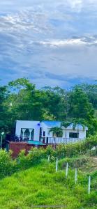una casa sentada en la cima de un exuberante campo verde en La Morenita en Puerto Triunfo