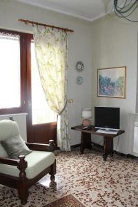 sala de estar con silla y escritorio con ordenador en La CoLLina del Moro, en Bracelli