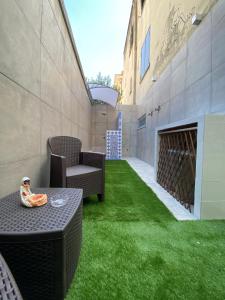 een patio met groen gras en een tafel en stoelen bij Dar Zohra in Pozzuoli