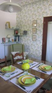 una mesa de comedor con platos verdes. en La CoLLina del Moro en Bracelli