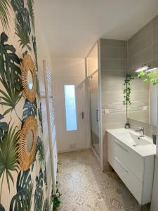 uma casa de banho com um lavatório e um espelho em Superbe appartement au calme avec parking gratuit. em Mérignac