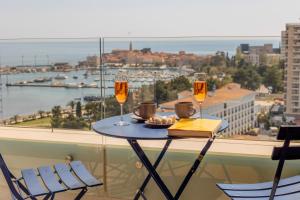 a table with two glasses of wine on a balcony at City Apartments 2 in Budva