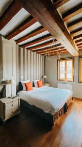 a bedroom with a large bed with orange pillows at Hôtel La Licorne & Spa in Lyons-la-Forêt