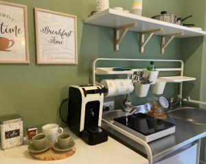 La Casa di LiLù في تارانتو: طاولة مطبخ مع آلة صنع القهوة وأكواب