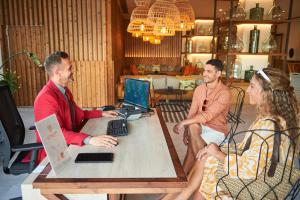 een groep mensen die rond een tafel met laptops zitten bij Corallium Dunamar by Lopesan Hotels - Adults Only in Playa del Inglés