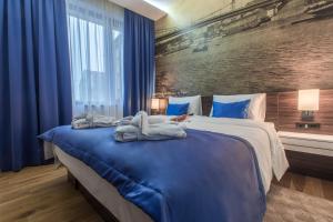 um quarto com uma cama grande e toalhas em Abba Hotel em Belgrado