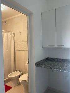 y baño con aseo y lavamanos. en Departamentos Céntricos Modernos - Pagos en USD - Consultar Disponibilidad por Teléfono en Gualeguaychú