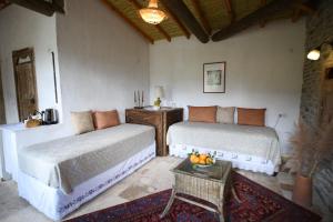 a bedroom with two beds and a table with a bowl of fruit at Nisanyan Hotel in Selçuk