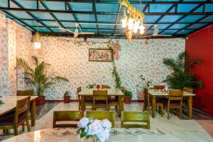 a dining room with tables and chairs and plants at Yorkshire Inn in Mount Ābu
