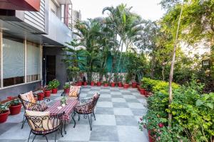 a patio with tables and chairs and plants at Yorkshire Inn in Mount Ābu