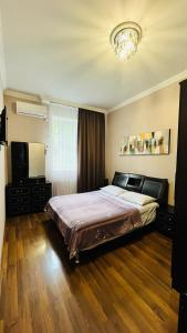 1 dormitorio con 1 cama grande y TV en Marinella, en Telavi