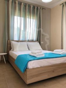 a large bed with two towels on top of it at Tasos Rooms in Prinos