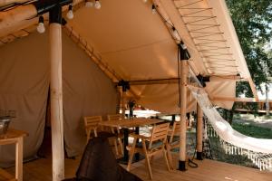 a tent with a table and chairs in it at Glamping Mandra Kanev in Leplyavo