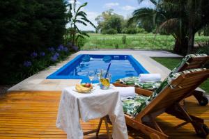 een tafel en een stoel naast een zwembad bij Casa de Campo Don Claudio in General Viamonte