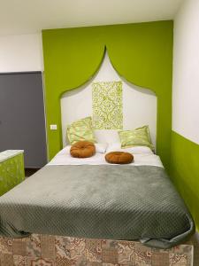um quarto com uma cama com uma parede verde em Dar Zohra em Pozzuoli