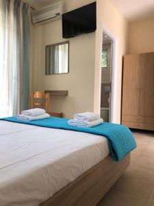 a bedroom with a large bed with towels on it at Tasos Rooms in Prinos