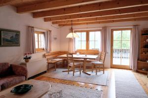 a living room with a table and chairs and a couch at Chasa Prümaran in Scuol