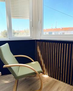 a green chair sitting in a room with a window at Sara&Sera in Umag