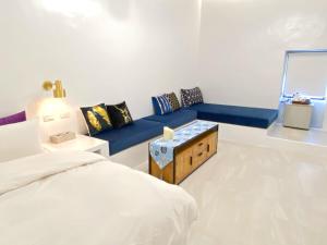 a bedroom with a blue couch and a blue bench at Sea Shore Hotel in Manzhou