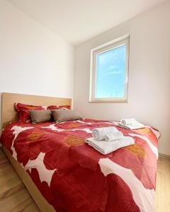 a bedroom with a red and white bed with towels on it at Sara&Sera in Umag