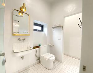 W łazience znajduje się toaleta, umywalka i lustro. w obiekcie Sea Shore Hotel w mieście Manzhou