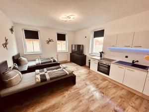 a large kitchen with white cabinets and a sink at Richter Apartments 3 in Finsterwalde