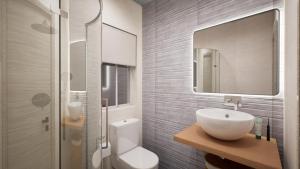 a bathroom with a sink and a toilet and a mirror at Gest in Mellieħa