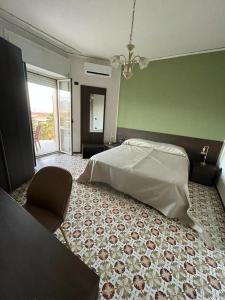 a bedroom with a bed and a chair in it at Hotel il Rosone in Trecase