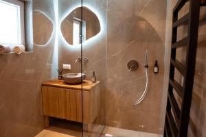 y baño con ducha, lavabo y espejo. en Pyramidenkogel Lodge en Keutschach am See