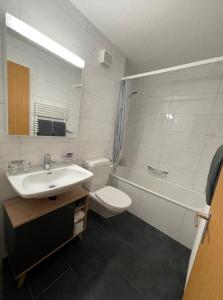 łazienka z umywalką, toaletą i wanną w obiekcie Appartamento Wyss w mieście Bivio