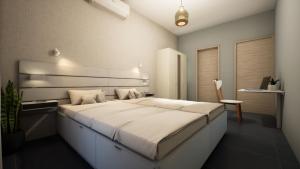 a bedroom with a large bed and a chair at Gest in Mellieħa