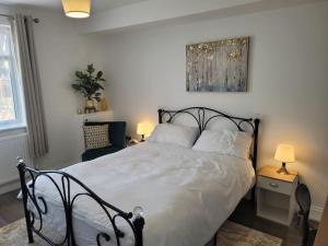 a bedroom with a large bed with white sheets and pillows at Newly Built Studio Flat Sleeps 2 in Kent