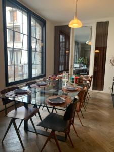 uma sala de jantar com uma mesa de vidro e cadeiras em B&B DRUUM em Bruxelas