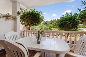 a white table and chairs on a balcony with trees at Beautiful Apartmento Amarilla Golf in San Miguel de Abona