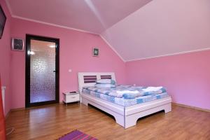 a bedroom with pink walls and a bed in it at Vila Roberta in Buşteni