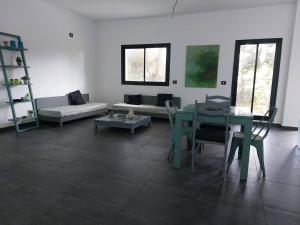 a living room with a table and a couch at The Green Blue House in Dar el Koudia