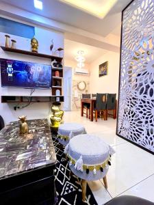 Airport Bliss Apartment+Balcony & Netflix + Prime في جايبور: غرفة معيشة مع تلفزيون وطاولة