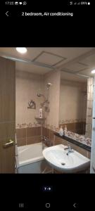La salle de bains est pourvue d'un lavabo, d'une baignoire et d'un miroir. dans l'établissement Джал Артис, à Bishkek