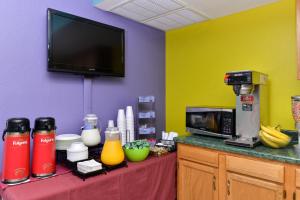 a kitchen with a stove top oven and a microwave at Americas Best Value Inn - Seymour in Seymour