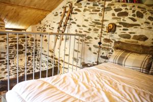 Bett in einem Zimmer mit einer Felswand in der Unterkunft il Bosco in Roccaforte Mondovì