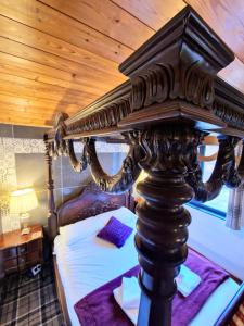 een hemelbed in een slaapkamer met een houten plafond bij Magpie 4 Hot Tub Huntersmoon-Warminster-Bath-Salisbury in Warminster