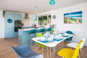 uma cozinha com mesa e cadeiras num quarto em Fairwinds,Bigbury on sea ,Three-bed Beach House em Bigbury on Sea