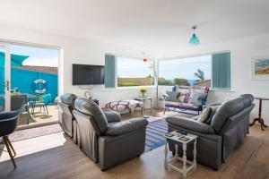 uma sala de estar com dois sofás e uma televisão em Fairwinds,Bigbury on sea ,Three-bed Beach House em Bigbury on Sea